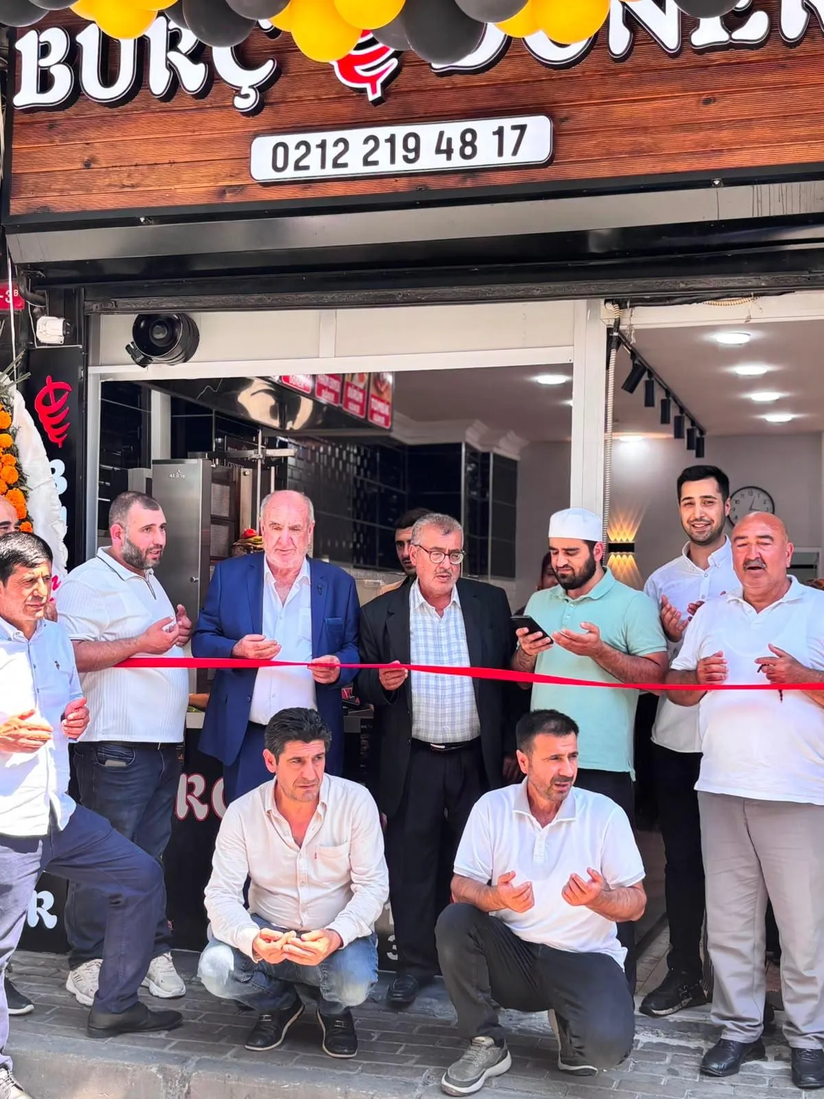 Açılış kurdelesinin kesildiği an, dua eden davetliler