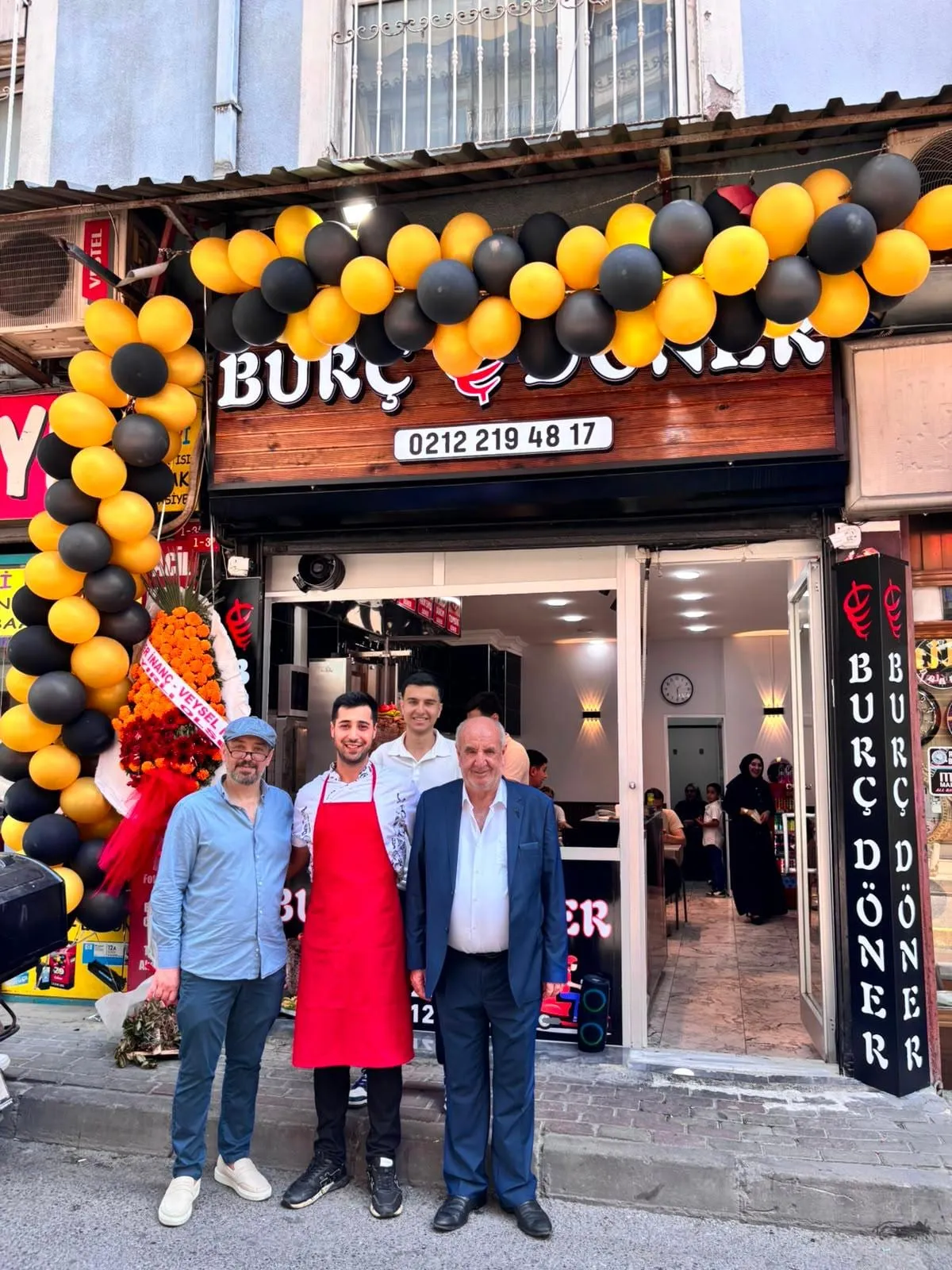 Açılış günü dükkanın önünde toplanan aile ve misafirler